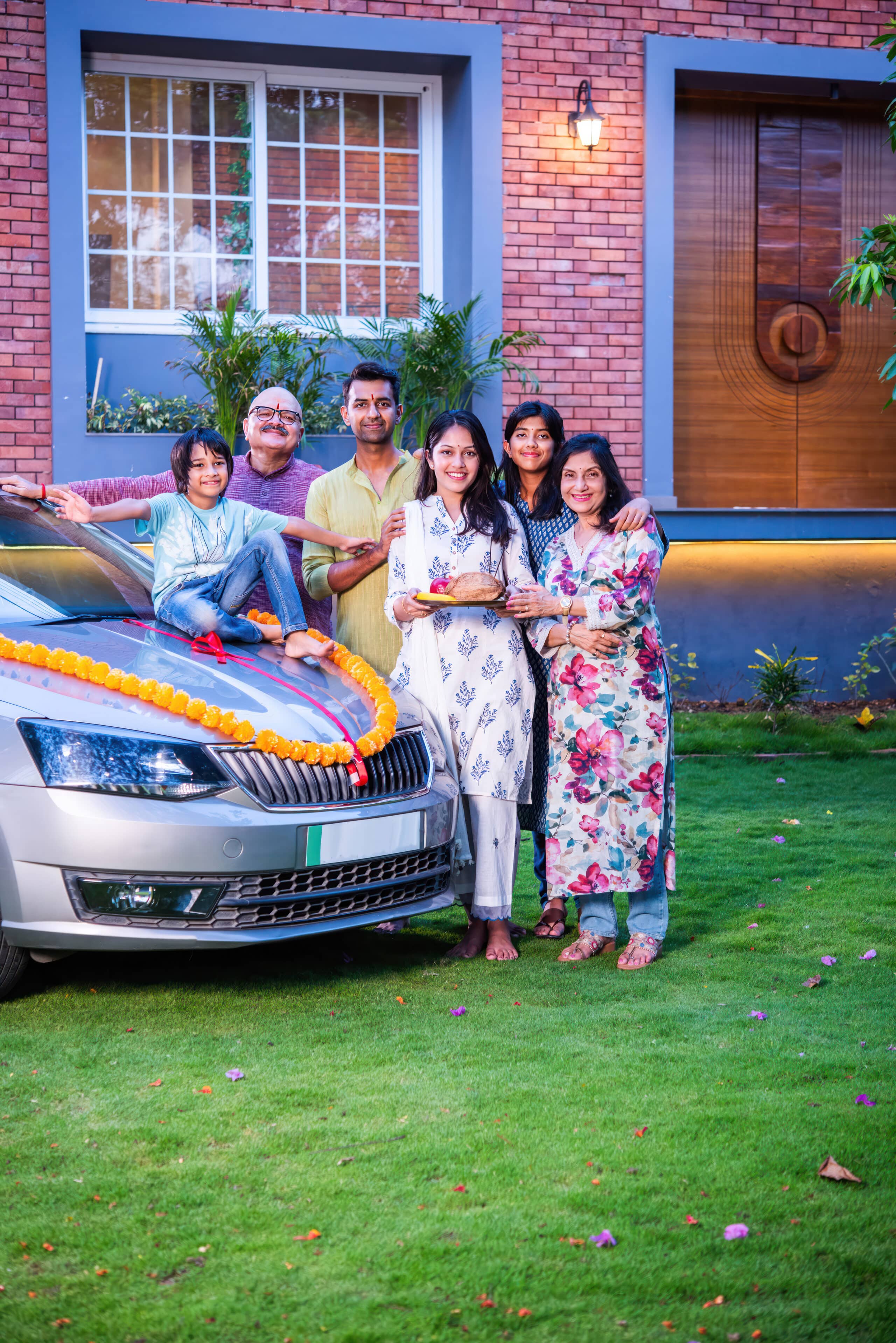 Indian asian family posing while welcoming new car at home