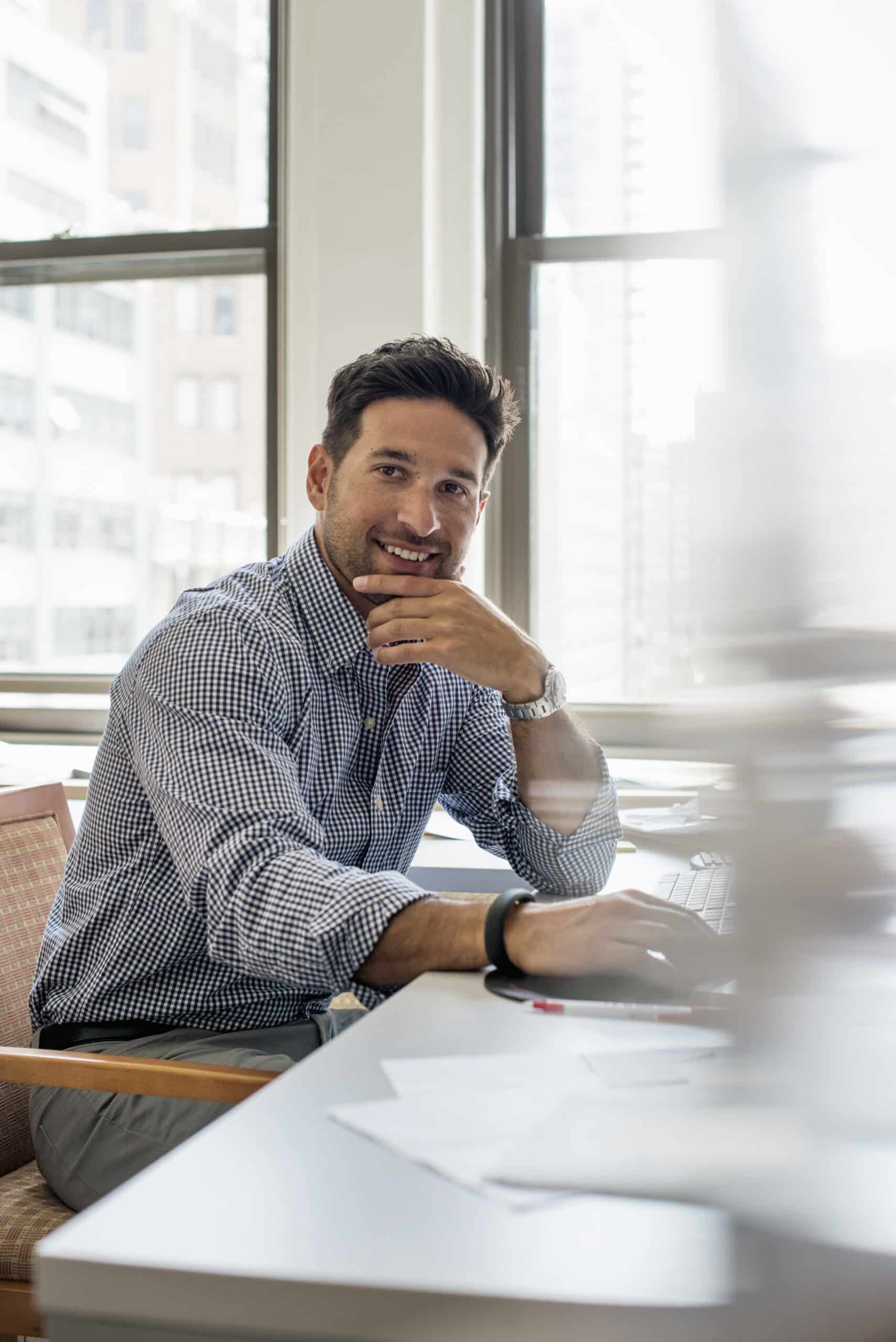 Office life. A man sitting at a desk looking at the camera.